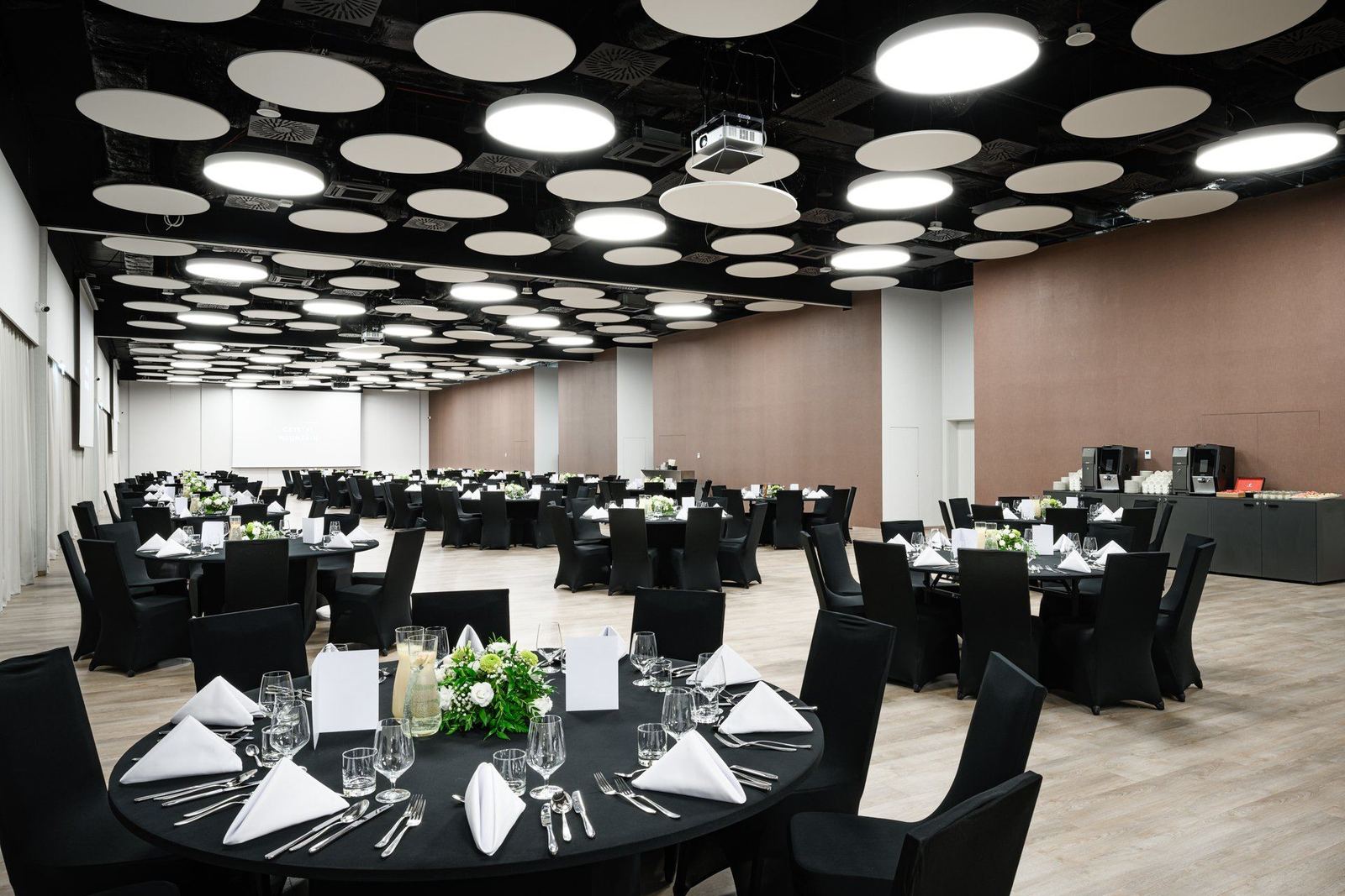 Sala balowa hotelu Crystal Mountain z okrągłymi stołami nakrytymi na czarno